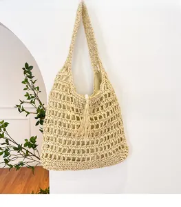 Detail of hand-woven straw beach bag featuring hollow mesh and elegant pearl clasp