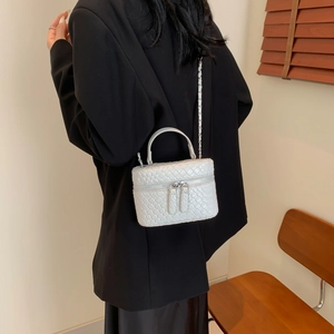Mini borsa vanity bianca a trama intrecciata con tracolla a catena su blazer nero