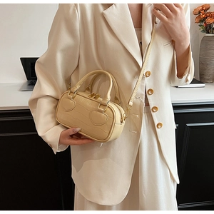 Detail of beige faux crocodile leather mini handbag with heart appliques and strap