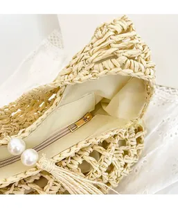 Detail of straw tote bag showing zipper closure with white pearls and fabric lining