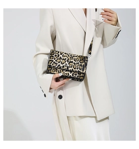 Detail of trendy leopard print handbag with crossbody strap and magnetic flap closure