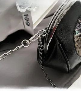 Detail of silver chain strap with lobster clasp on black lychee grain shell bag