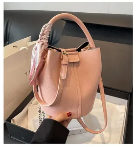Sac seau en cuir rose avec détail de foulard en soie dans un coffret cadeau noir
