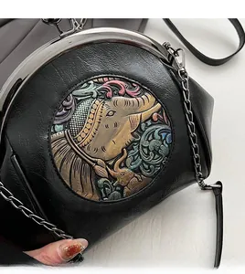 Detail of black vintage leather shell bag with elephant relief and silver chain strap
