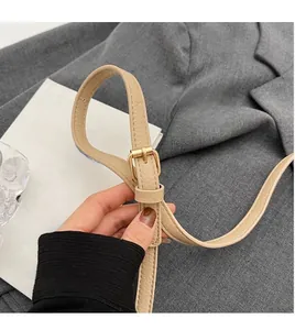 Détail de la bandoulière réglable en similicuir beige avec boucle en métal doré et grainé