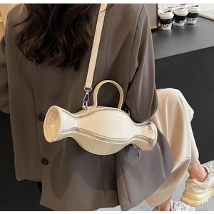 Détail du sac bandoulière crème avec forme géométrique fluide et zips argentés