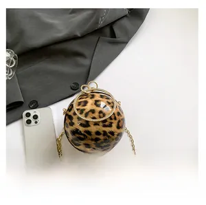 Macro shot of leopard print spherical bag with golden metal chain and ring handle
