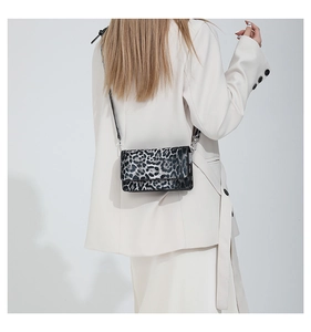 Close-up of leopard pattern crossbody bag styled with a white blazer for a chic look