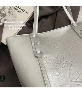 Detailed shot of silver tote bag showing stitched handle seams and metallic texture