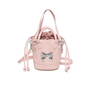 Pink bucket bag with silver bow and adjustable strap for crossbody or handbag use