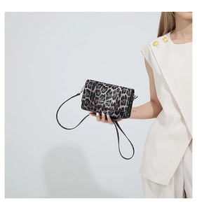 Detail of vintage leopard print leather handbag with shoulder strap and brand lettering