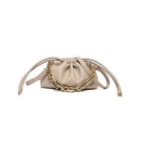Minimalist beige dumpling bag with chunky gold chain strap and gathered leather design