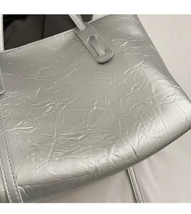 Close-up of silver tote bag showing crinkled metallic texture and durable stitching