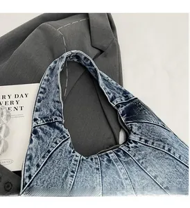 Detailed shot of acid-washed denim handbag featuring reinforced contrast stitching and texture