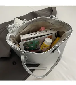 Top view of spacious silver tote bag interior showing compartments and everyday items