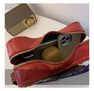Vue intérieure montrant la capacité compacte de ce sac bandoulière rouge en forme de guitare