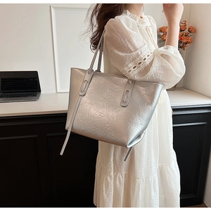 Close-up of a silver crinkled tote bag worn on shoulder for a modern chic style