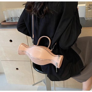 Détail du sac à main rose en forme d'haltère avec logo argenté et bandoulière