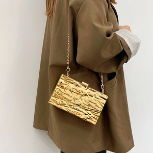 Metallic quilted crossbody bag with textured gold foil finish and elegant chain strap