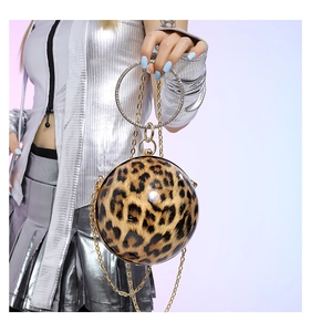 Detail of leopard print spherical evening bag with rhinestone handle and gold chain strap
