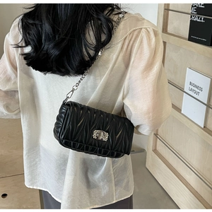 Detail of black Matelasse quilted crossbody bag featuring a crystal-embellished twist lock