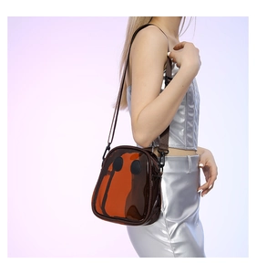 Detail of brown transparent PVC crossbody bag with minimalist black circular decorations