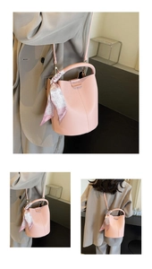 Vue détaillée du sac seau rose en cuir grainé avec foulard en soie décoratif et bandoulière