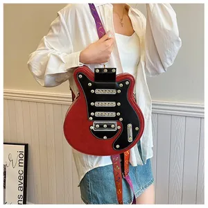 Détail d'un sac bandoulière en forme de guitare avec rivets dorés et sangle musicale
