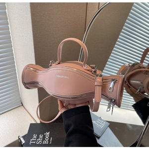 Vue détaillée d'un sac à main rose en forme de bonbon en cuir avec fermetures éclair