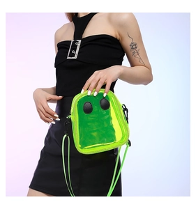 Detail of neon green transparent PVC crossbody bag with cartoon ghost face decoration
