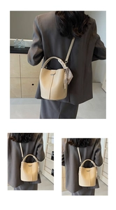 Détail du sac seau beige avec texture litchi et foulard en soie décoratif sur l'anse
