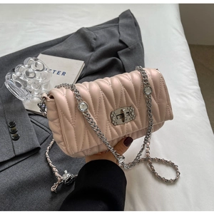 Detail of light pink quilted crossbody bag with rhinestone chain and metallic lock