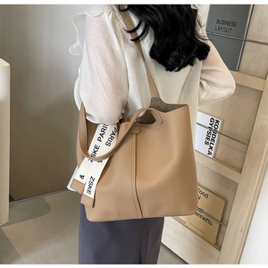 Close-up of khaki tote bag with textured finish and Paris branded textile strap