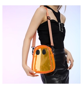 Detail view of orange transparent PVC crossbody bag with funny ghost eye patches