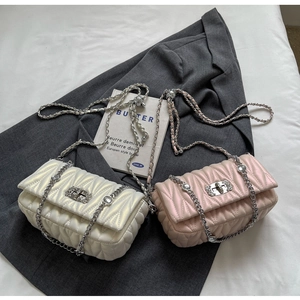 Detail of quilted leather crossbody bags with rhinestone trim and silver chain straps
