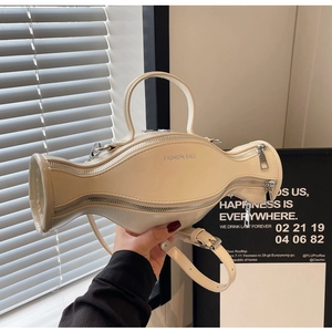 Détail du sac à main crème en forme de bonbon avec imprimé Fashion Ball et finitions argent
