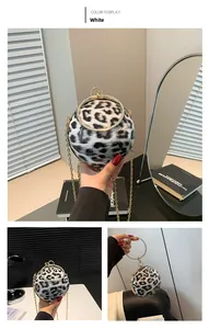 Detail of spherical leopard print evening bag with golden rhinestone ring handle and chain
