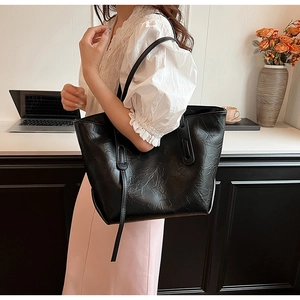 Detail of black tote bag featuring artistic pleated texture for stylish daily commuting