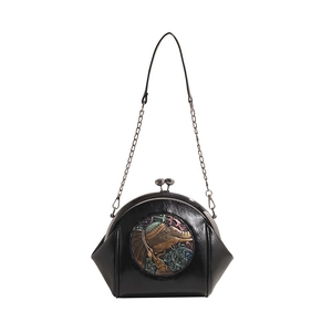 Elegant black shell shoulder bag featuring a vintage elephant relief and chain strap