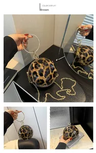 Close-up of leopard print spherical handbag with sparkling rhinestone ring handle and chain