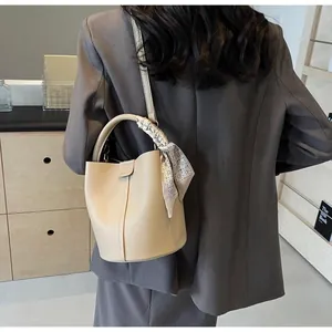 Sac seau chic en cuir crème motif litchi avec poignée décorée d'un foulard en soie