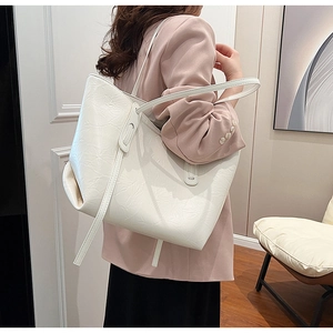 Detail of white large tote bag featuring textured PU leather and long shoulder straps