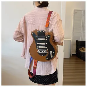 Détail du sac à bandoulière en forme de guitare avec rivets et sangle motif musique