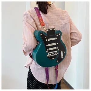 Détail du sac guitare avec garniture noire, rivets et bandoulière aux motifs musicaux