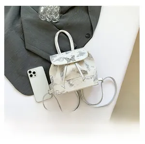 Detail of white mini backpack with butterfly print and silver metal butterfly clasp