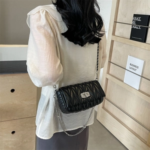 Quilted black leather crossbody bag with silver chain strap and metal lock detail