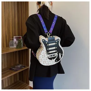 Détail d'un sac à dos en forme de guitare avec motif monogramme et sangles violettes