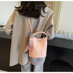 Détail de vue arrière d'un sac seau rose orné d'un foulard en soie sur la poignée