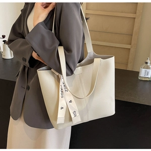 Detail of off-white lychee leather tote bag with stylish printed silk ribbon and straps