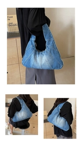 Detail of blue denim hobo bag featuring contrast stitching and crescent moon shape